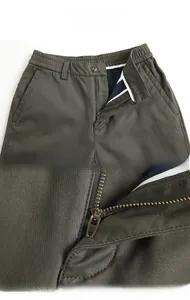 Detail of army green casual trousers showing elastic waistband and metal zipper closure