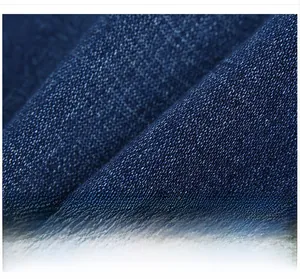 Close-up of deep blue denim fabric with visible twill weave texture and high durability