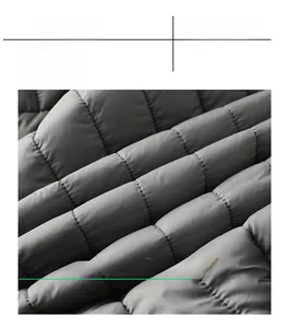 Detailed macro view of gray quilted fabric showing windproof stitching on winter jacket