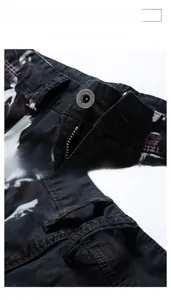 Detail view of cargo shorts featuring a custom metal button and white splash ink print