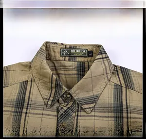Close-up of khaki plaid shirt collar with metal buttons and classic pointed lapel detail