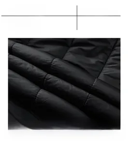 Detailed close-up of high-quality quilted fabric on black winter jacket with windproof lining