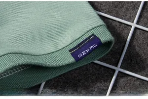 Close-up of green Polo shirt cuff with ribbed hem and JEANS woven label detail