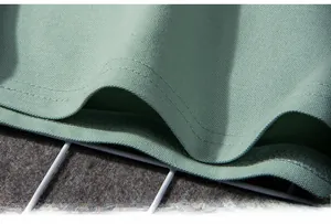 Detailed macro view of the double-stitched hem on a light green polo shirt with piqué texture