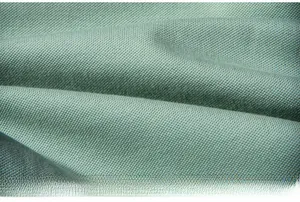Macro shot of breathable light green pique fabric with honeycomb mesh texture and soft drape