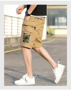Detail of khaki cargo shorts with camouflage pocket flaps and outdoor utility design