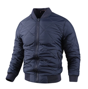 Detail of navy blue quilted jacket with diamond patterns and ribbed cuffs and collar