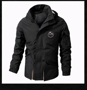 Detail of black hooded jacket featuring outdoor chest patch and tactical arm pocket