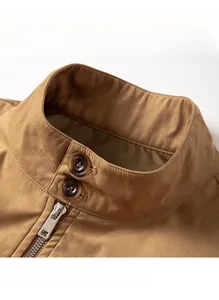 Detailed view of the stand-up collar with amber buttons and metal zipper on the tan jacket