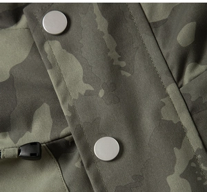 Detail of camouflage outdoor jacket featuring metallic snap buttons and adjustable drawstrings