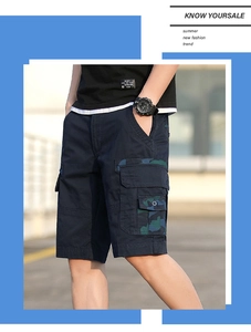 Detail view of navy blue cargo shorts featuring camouflage flap pockets and twill cotton fabric