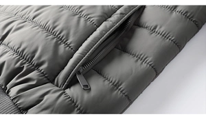 Close-up of horizontal quilted dark gray jacket featuring a sleek zipper pocket