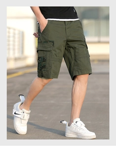 Detail view of olive green cargo shorts featuring camo side pockets and cotton fabric