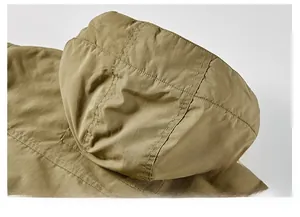 Close-up of windproof hood stitching and durable khaki fabric on a winter jacket