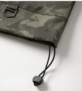 Close-up of camo jacket hem with a D-ring and adjustable elastic drawstring detail