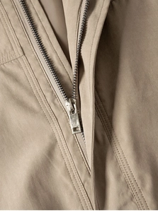 Nahaufnahme des Metallreißverschlusses und der Präzisionsnähte an der Khaki-Jacke