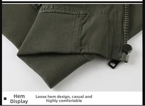 Detail of olive green flight jacket showing ribbed hem and metallic zipper close-up