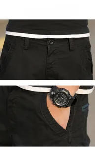 Detail of black work shorts showing flat waist with single button and side slanted pockets