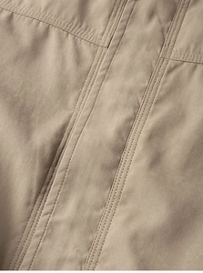 Nahaufnahme der khakifarbenen Outdoor-Jacke mit verstärkten Nähten und Stoffstruktur