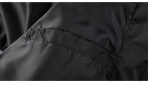 Macro detail of high-quality polyester fabric texture and pocket stitching on black jacket