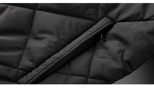 Detail of a black quilted jacket showing a zip pocket and diamond stitching patterns