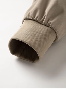 Detailaufnahme der khakifarbenen Outdoorjacke mit gerippten Bündchen und feiner Naht