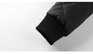 Detailed close-up of black quilted jacket sleeve with premium elastic ribbed knit cuff