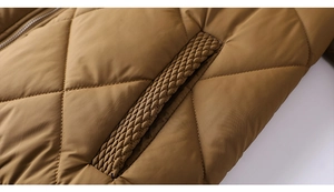 Détail de la veste matelassée camel avec coutures en losanges et bordure tressée