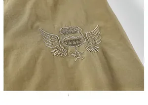 Detailed close-up of high-density khaki cotton fabric and military-style sleeve embroidery