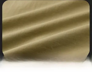 Vista macro del tessuto kaki del gilet da pesca che mostra la trama di qualità