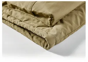 Macro shot of khaki winter jacket hem featuring precise multi-row reinforced stitching