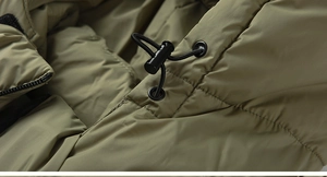 Dettaglio del cappuccio del parka verde militare con cordino elastico regolabile e fibbia nera