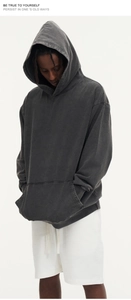 Detail of heavy washed charcoal grey hoodie featuring dropped shoulders and kangaroo pocket