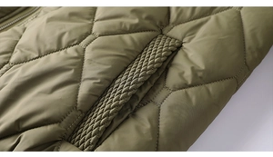 Close-up of olive green quilted jacket with diamond patterns and woven edge detail