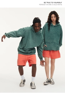 Detail of heavyweight washed green hoodie with drop shoulder and kangaroo pocket design