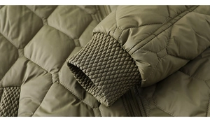 Detail of olive green quilted jacket featuring ribbed elastic windproof cuffs and honeycomb pattern