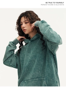 Close-up of vintage washed green cotton hoodie featuring drop shoulders and large pocket