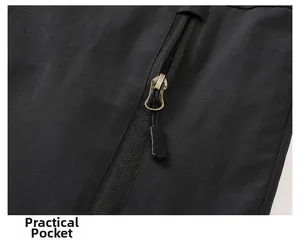 Close-up of a functional jacket pocket with a bronze zipper and textured black fabric