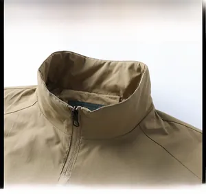 Detail view of khaki jacket stand collar and metal zipper closure for men