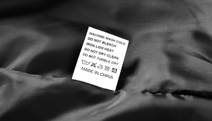Detailed view of garment care label with washing instructions on black inner lining