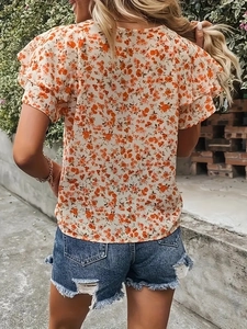 Détail du haut d'été à fleurs avec manches à volants et encolure ronde classique
