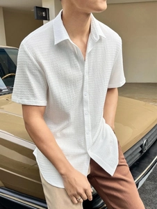 Detailed view of the textured seersucker fabric on a white men's short sleeve shirt