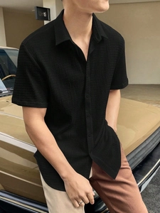 Close-up of the textured seersucker fabric and collar detail of this black men's summer shirt