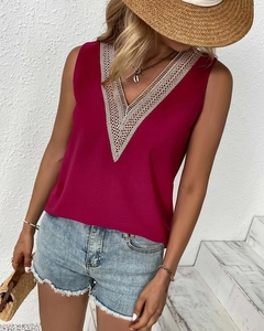 Detail of elegant V-neckline with white lace crochet on a magenta sleeveless summer blouse