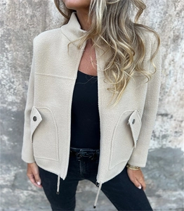 Detail of waffle textured wool-like fabric on beige zipper jacket with drawstrings