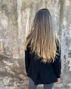 Detail of long straight balayage hair extensions in dark brown to blonde gradient