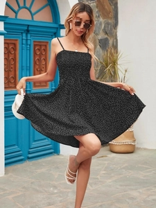 Detail of black polka dot mini dress with elastic shirred bodice and thin straps
