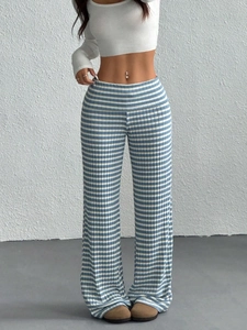 Detail of blue and white striped knit flared pants with elastic ribbed texture