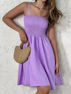 Detailed view of the smocked bodice and white polka dot print on purple sundress