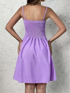 Detail showing the shirred elastic back and purple polka dot pattern of the summer dress